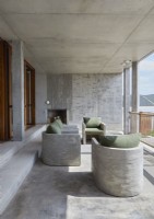 Built-in concrete chairs on balcony with fireplace and sea views