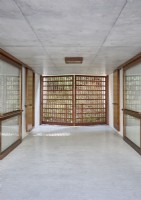 Slatted wooden doors in contemporary concrete hallway