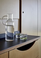 Modern glass jug and drinks of water on kitchen worktop
