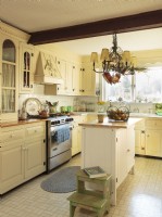 Several reclaimed arched top doors were used to add wall-mounted cabinets. Refinished antique floorboards into countertop confer a historic pedigree. 