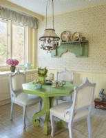 Awash in country charm, the breakfast nook centers on a bright green table circled by thrift shop chairs. 