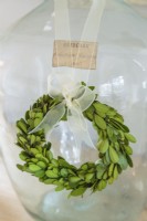 A tiny green wreath embellishes a vintage European demi-john bottle.