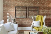 A marigold throw adds a bold stroke of pigment against the brick wall.
