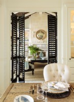 Tall wooden shutters are used on lily of doors between the living and dining room.