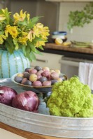 When a space has a neutral color scheme, even the most ordinary items stand out, such as vibrant veggies nestled in a galvanized tub. 