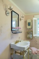 Gold-flecked pink wallpaper dresses up the small bathroom