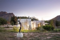 Sculpture in front of modern house at twilight