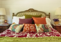 A carved, upholstered headboard imparts a French touch.