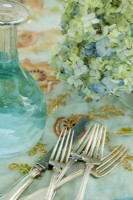 Vintage silverware and an etched-glass carafe are fitting for the stylish yet simple table setting.
