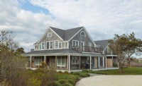 The upper story of the classic Nantucket cottage harbors living spaces and the master bedroom.