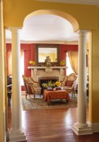 Golden walls and an arched opening elegantly frame the entrance to the living room. 