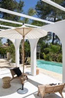 Simple chairs and parasol next to pool in summer