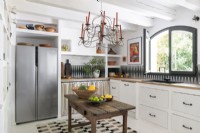 Chandelier over simple wooden table in modern country kitchen