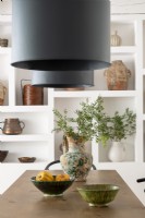 Large black modern lampshades over country dining table