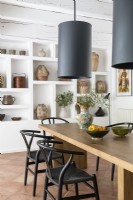 Display of ceramics on wall of shelving in modern country dining room
