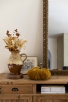 Dried flower arrangement in ceramic jug and velvet pumpkin ornament