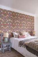 Floral wallpapered feature wall in country bedroom
