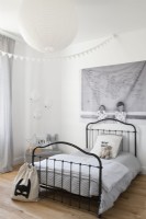 Black iron bed frame in childrens white bedroom