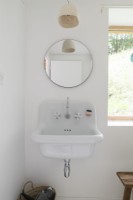 Vintage style bathroom sink with circular mirror above
