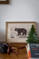Painting of a bear next to ceramic tree on sideboard - detail
