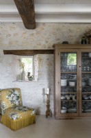 Old wooden dresser and floral chair in country dining room