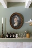 Classic portrait painting in frame above kitchen shelf