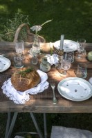 Detail of rustic outdoor dining table laid for lunch
