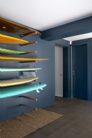 Dark grey painted modern hallway with surfboard storage rack