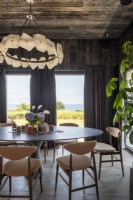 Chandelier over large round dining table with sea views