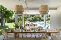 Covered outdoor dining area with view to garden and swimming pool