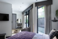 Small dressing table and patio doors in modern bedroom`