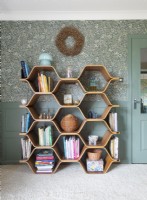 Unusual shelving unit against floral wallpapered wall