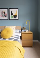 Colourful modern bedroom - detail of wooden bedside cabinet