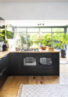 Double ovens with gas hob in modern kitchen with garden view