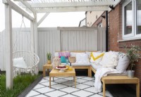 Covered outdoor seating area with swing seat and sofas