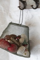 Metal chainlink bag filled with seaside finds from the beach