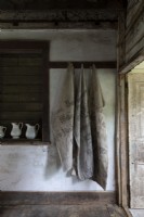Sacks hanging on clothes hooks in rustic hallway