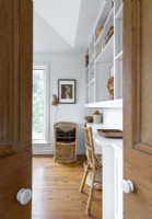 View through wooden doors into white and wood home study