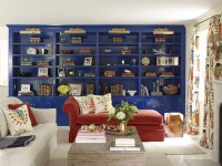 Living room with blue lacquered bookshelevs and red settee.