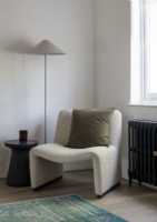 Modern boucle armchair with floor lamp and cushion