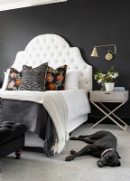 bedroom with white deep buttoned headboard against black wall