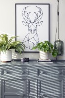 Painted sideboard with potted plants and framed print