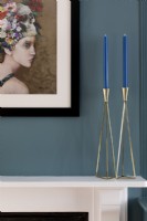 Blue painted walls with botanical art and brass candle sticks