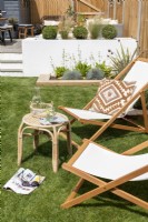 Deckchairs and bamboo side table on lawn