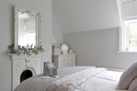 white scandi bedroom with fireplace and garlands at Christmas time