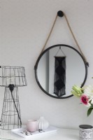 Dressing table detail with round mirror and modern lamp
