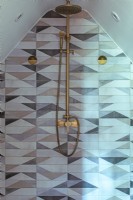 Loft Bathroom with brass shower with geometric tiles