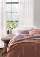 Pink throw on a double bed with pink gingham bedlinen
