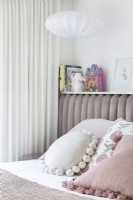 Children's bedroom with upholstered headboard and pastel palette