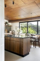 Large picture window in kitchen with walnut finishes